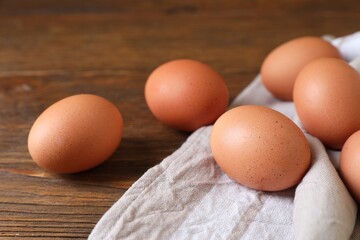 Raw brown chicken eggs on wooden table