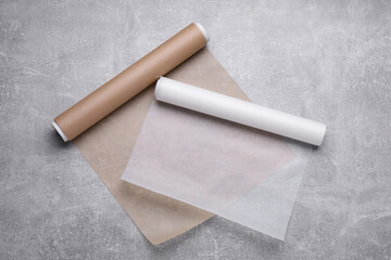 Rolls of baking paper on light grey table, flat lay