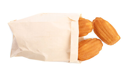 Paper bag with delicious madeleine cakes on white background, top view