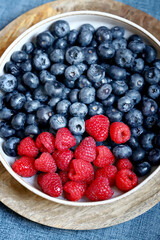 Fresh selected raspberries and blueberries in a bowl. Healthy snack. Berries for dessert. Close-up.