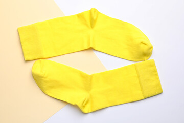 Obraz na płótnie Canvas Pair of new yellow socks on color background, flat lay