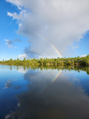 Rainbow and clouds over Pine Glades Lake in Everglades National Park, Florida on sunny autumn morning.