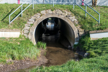 Abwasserkanal, Tunnel mit Spiegelung und Licht am Ende 