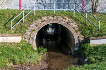 Abwasserkanal, Tunnel mit Spiegelung und Licht am Ende 