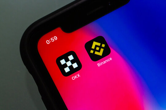 Vancouver, CANADA - Nov 19 2022 : Conceptual image OKX and Binance icons on an iPhone screen.