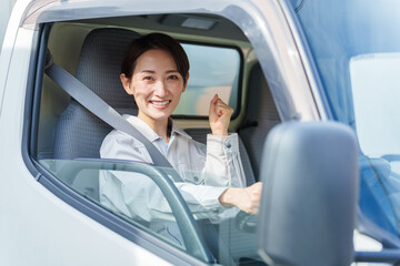 運転席でガッツポーズをする女性