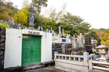 Fototapeta na wymiar Traditional japanese cemetery tombstones and statues