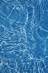 Defocus blurred transparent blue colored clear calm water surface texture with splashes and bubbles. Trendy abstract nature background. Water waves in sunlight with copy space. Blue watercolor shining