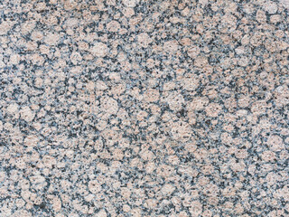 Granite texture. Natural granite with a grainy pattern. Stone background. Solid rough surface of rock. Durable construction and decoration material. Close-up.