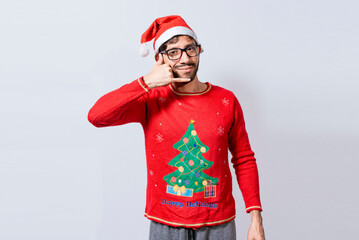 Obraz premium People in Christmas clothes making a call gesture with their fingers. Man in christmas hat imitating a phone conversation, Young latin man in christmas hat making a call gesture isolated