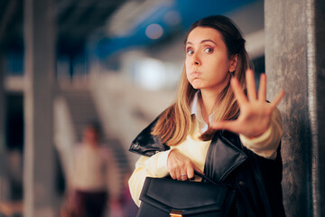 Stressed Woman Holding her Purse Pushing a Thief Away. Fearful woman feeling in danger setting personal boundaries 
 - obrazy, fototapety, plakaty