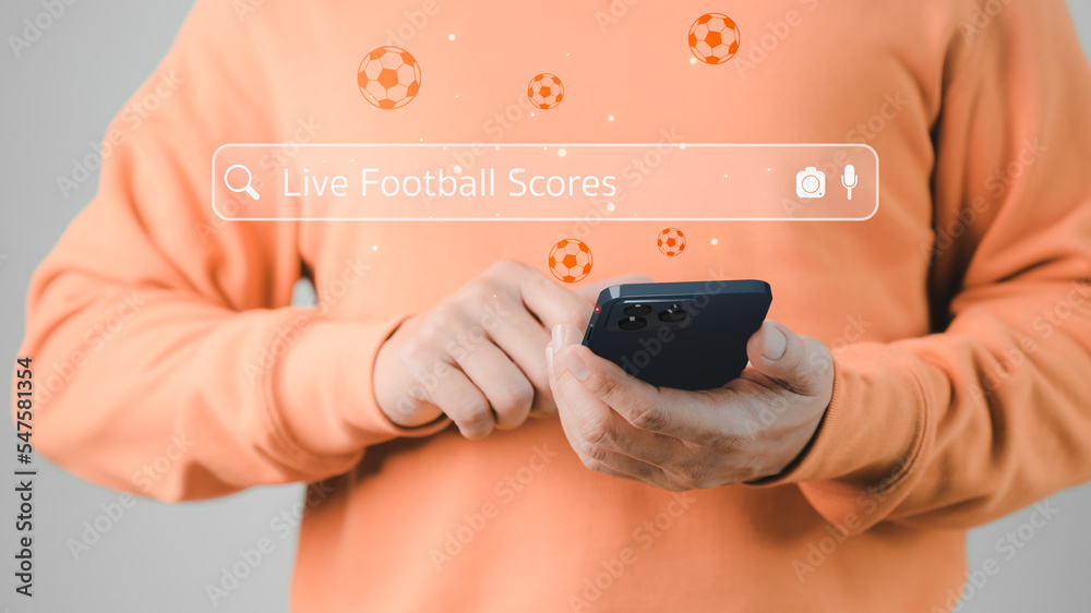 Leinwandbilder football fan's holding smartphone for search live football scores. searching browsing internet data 