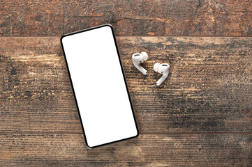 mockup modern smartphone with blank white screen. earphones and mobile phone with blank screen on...