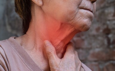 Redness at neck of Asian woman. Concept of sore throat, pharyngitis, laryngitis, thyroiditis, or dysphagia.