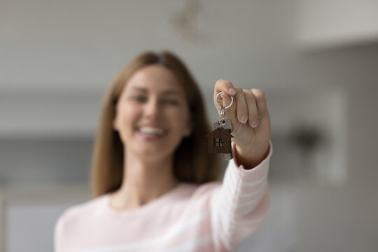 Smiling young woman showing keys on camera, close up shot, focus on female hand holding bunch. Tenancy, happy homeowner enjoy relocation day to new own first apartment, bank loan, affordable dwelling