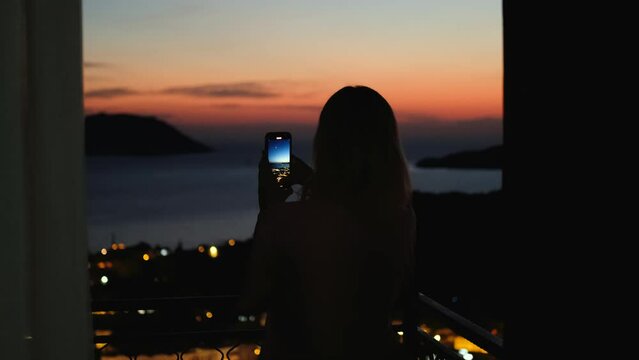 woman filming sunset in Kas city Turkey on phone