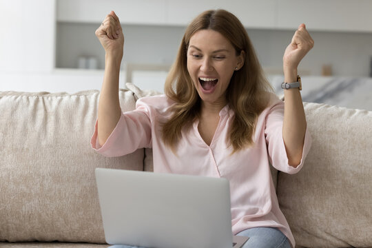 Woman looks at laptop screen, screams with joy celebrate great news, get unbelievable commercial offer, discounts and sell-out. Moment of victory, on-line lottery gambling win, achievement and success