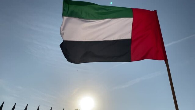United Arab Emirates Flag waving in the wind, bright blue Sky Background, The national symbol of UAE, United Arab Emirates, 4K video