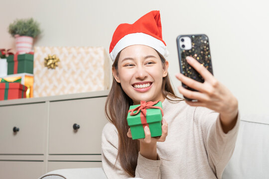 Celebrate on Christmas, New year season, pretty asian young woman, girl holding smartphone take photo gift green box after her received, get present on merry xmas day. Happy, cheerful on festival.