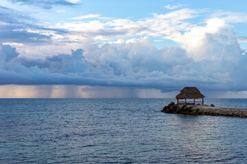 structure en bord de mer avec des gros nuages et de la pluie au loin