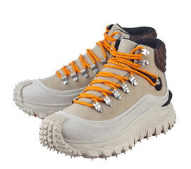 Beautiful pair of beige suede winter boots with orange alpine lacing on a massive anti-slip sole, isolated on a white background.