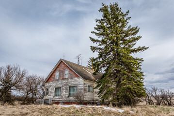 Blue sky over an old, abandoned pink home on the prairies in Saskatchewan