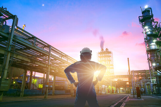 Worker working in petroleum industrial factories on sunset