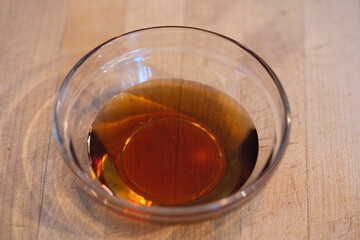 Clear bowl of maple syrup.  