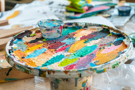 Spots of bright paint in the palette in the art workshop