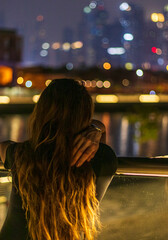 Shot of a young woman looking ahead at night. People