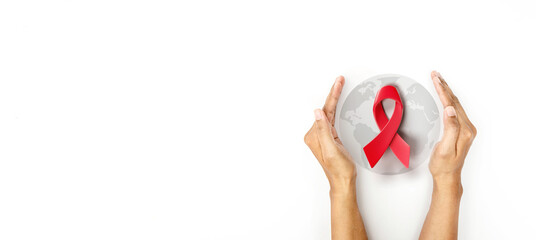 Hand covered 3d red ribbon on world map background, campaign for World AIDS Day on 1 December - 547604388
