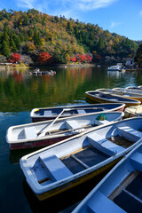 紅葉で色づいた池の周りには多くの魚釣り用のボートが舫ってある
