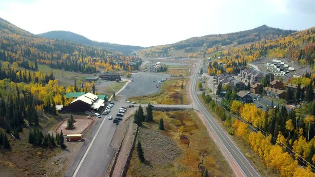 Drone shot of a city view with highway and tree-covered land in Brian Head, Utah, United States