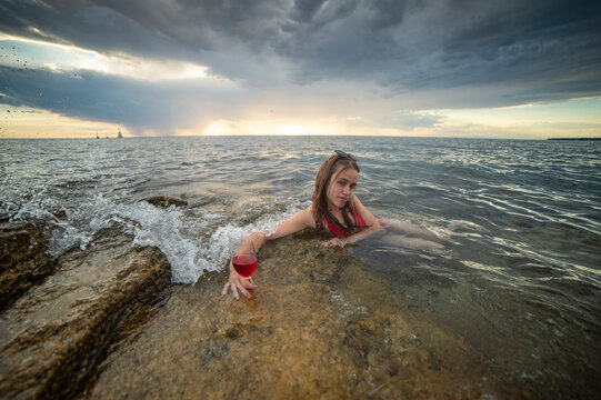 A young, beautiful woman relaxes in the water of the Adriatic Sea in Croatia