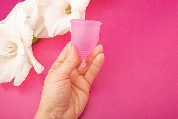menstrual cup in hand, eco-friendly feminine hygiene product, sanitary container for collecting...