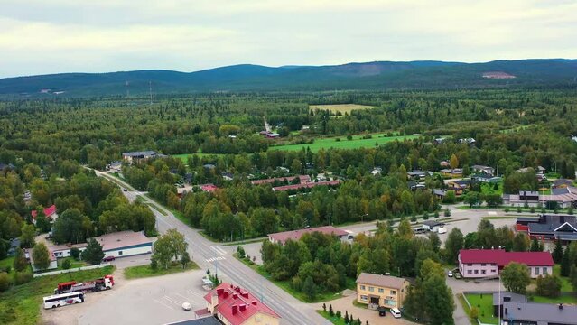Drone shot flying above the beautiful green landscape of Inari surrounded by mountains, Finland