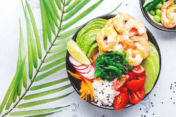 Hawaiian poke bowl with shrimp, avocado, radish, carrot, tomato, chuka seaweed and white rice. Soy...