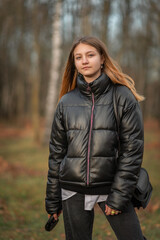 Portrait of a young beautiful woman in a dark autumn jacket.