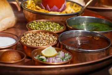 Famous maharashtrian cuisine, street food called misal pav which includes spicy curry, sprouts,...