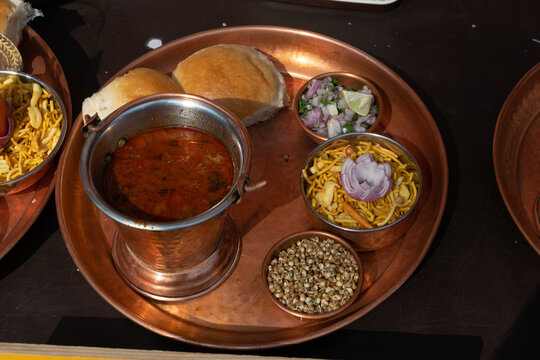 Famous maharashtrian cuisine, street food called misal pav which includes spicy curry, sprouts, snacks, bread, salad. Kolhapur, Nasik, Pune, Katakir, chutney, onion, rassa, tarri, farsan, lemon, junk