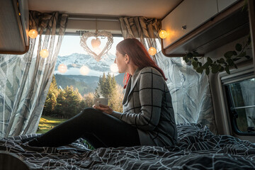 Frau genießt den Ausblick aus dem Camper Van im Urlaub