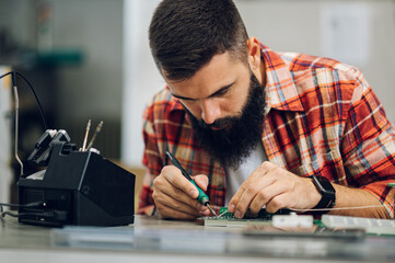 Electronics engineer working in a workshop with tin soldering parts
