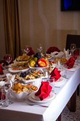 the table in the room is set in red tones with food for the holiday
