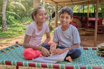 Indian kids reading book together rural village