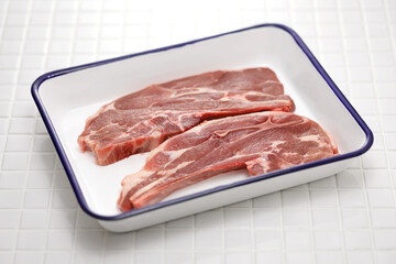 raw lamb shoulder chops on butcher tray