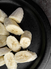 Raw Banana slices on black plate