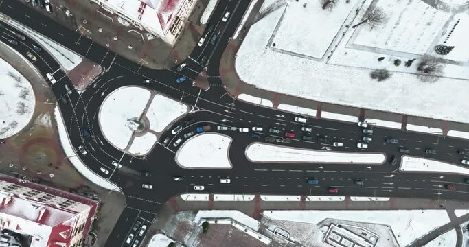 accelerated video 4x aerial view above at crossroads on winter road junction with heavy traffic in city with snow