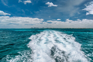 Trail of water left by a boat in the lake, travel image on a boat in Caribbean Ocean near Cancun,...