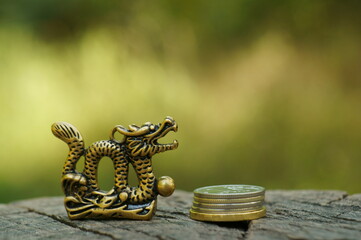 Dragon figurine with coins close-up. Chinese symbol. Esotericism and feng shui.