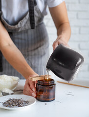 Woman making decorative aroma candle at table, closeup